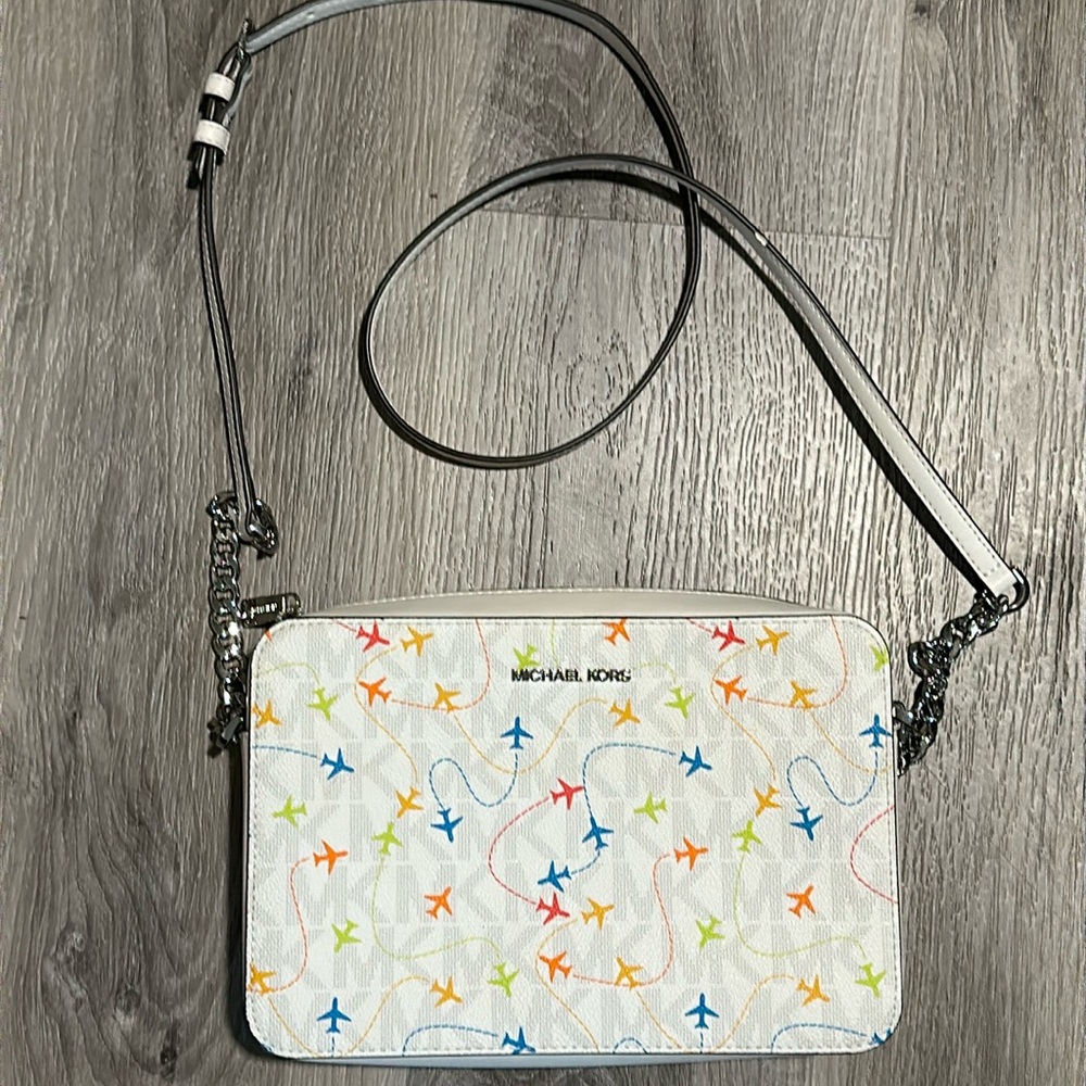 Like new Michael Kors medium sized airplane multi colored white purse w/ chain.